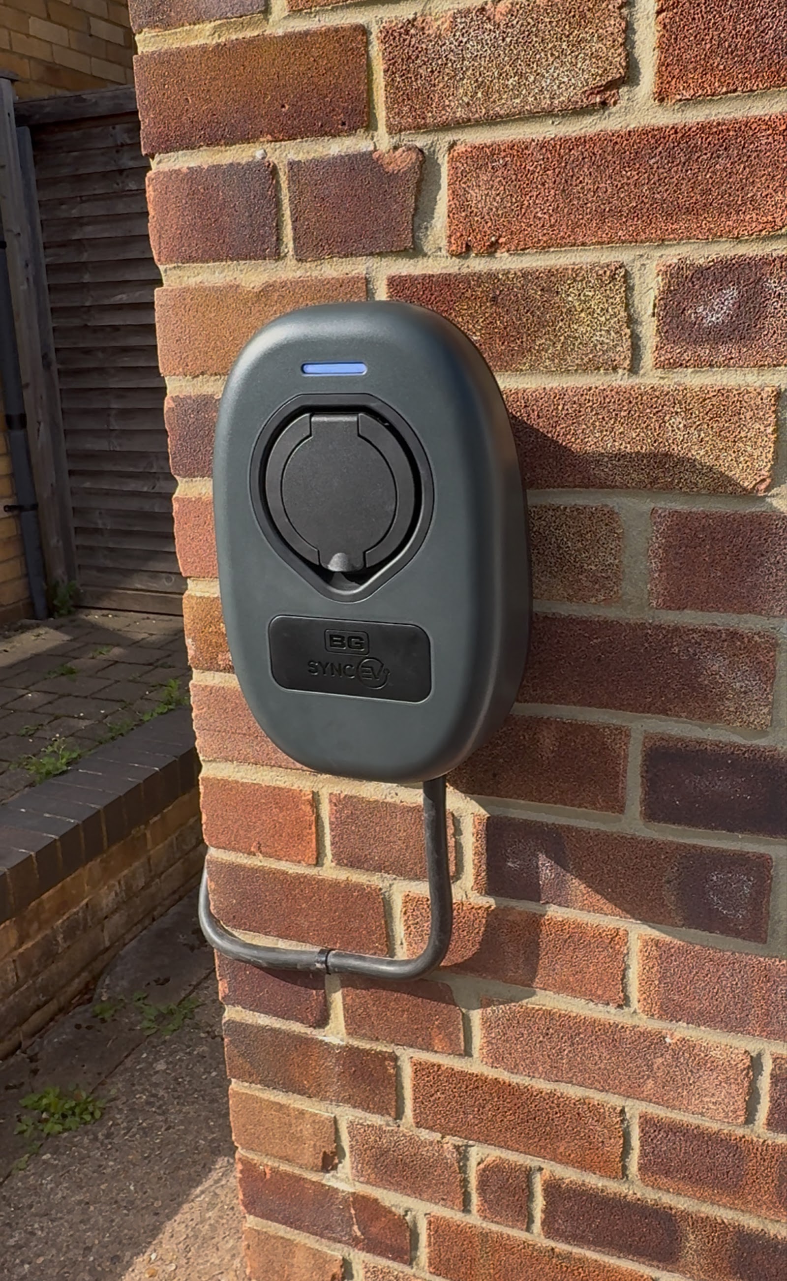 A home car-charging point installed by SB Electrical, the supply cable run neatly down a brick wall