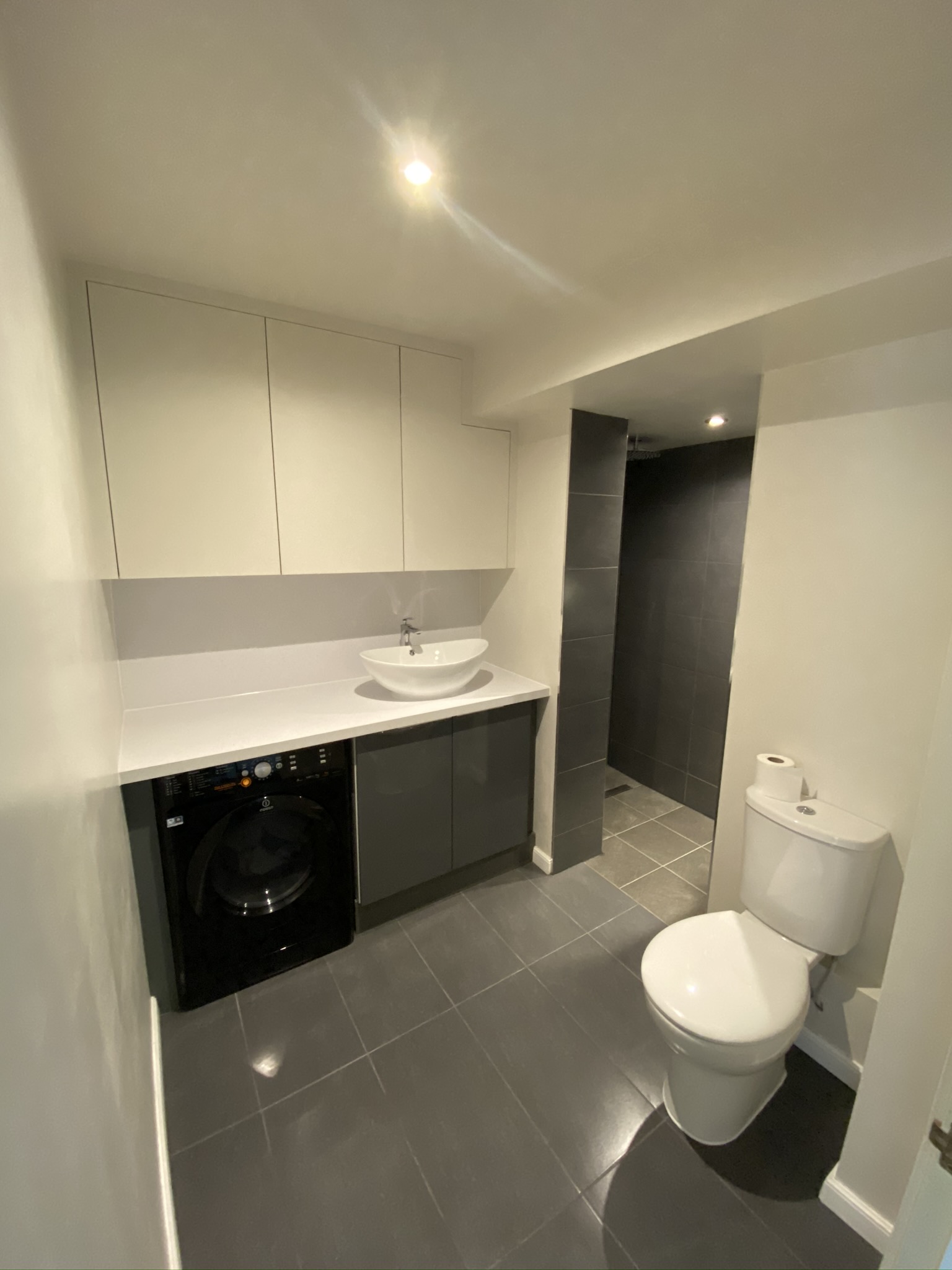 Walk-in shower room with recessed ceiling lights and concealed appliance electrics — every fitting placed to the correct bathroom zone.